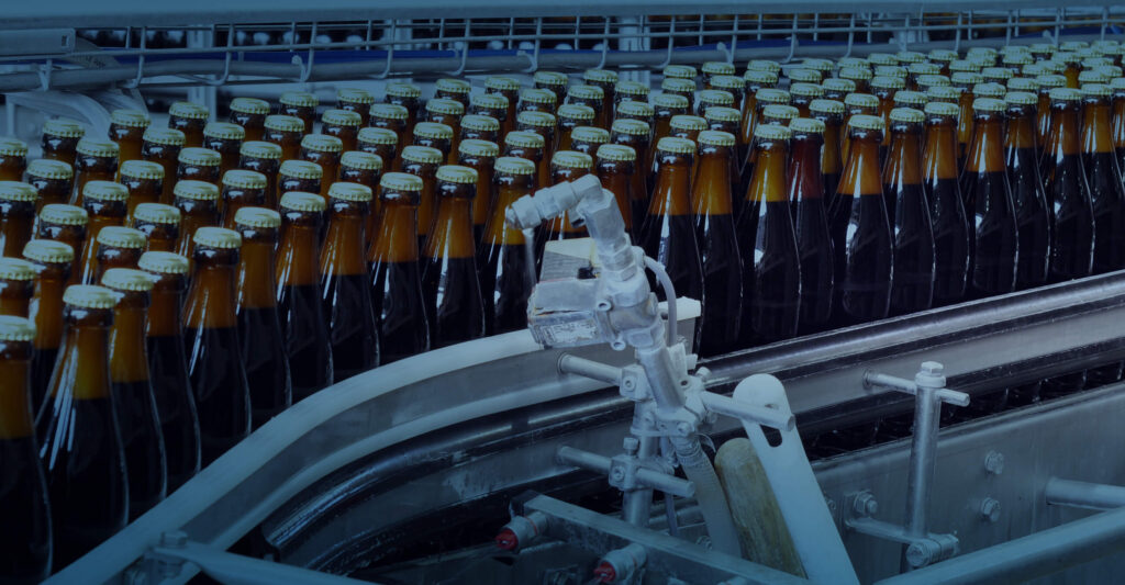 Beer bottles on a conveyor that are filled and capped and sealed