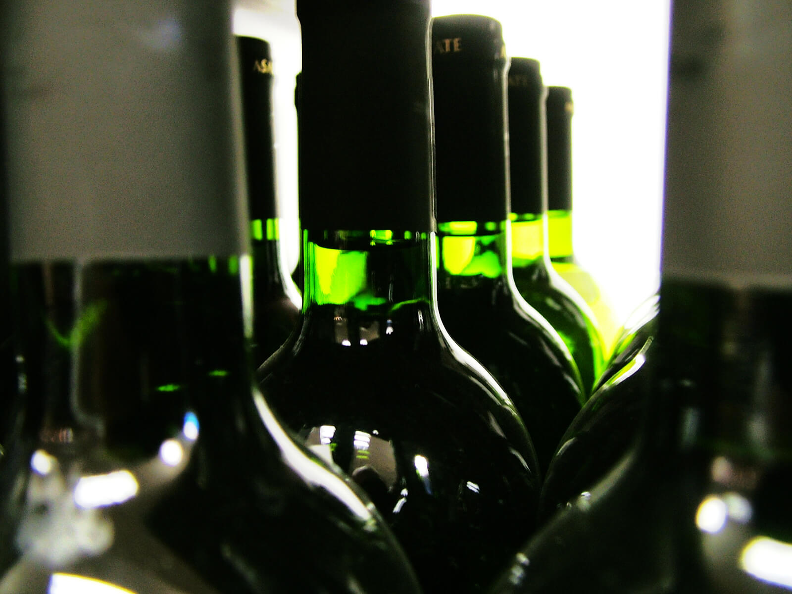 closeup of wine bottle necks on a shelf